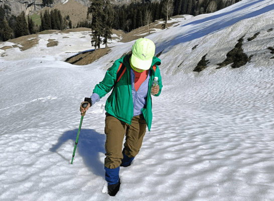 A hiker treks through a snowy mountain